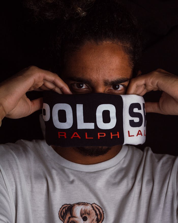 Services-02 Close-up portrait of a man with Polo Ralph Lauren branding. Dark background enhances focus.