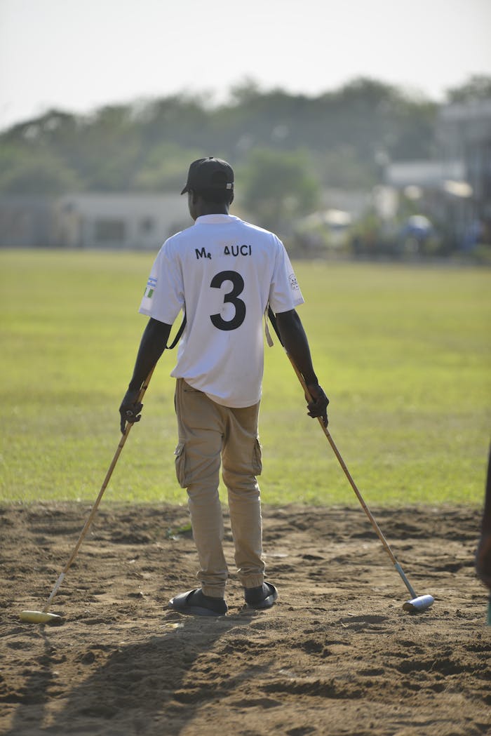 digital A polo player stands on the field in Abuja, preparing for a match under bright daylight.